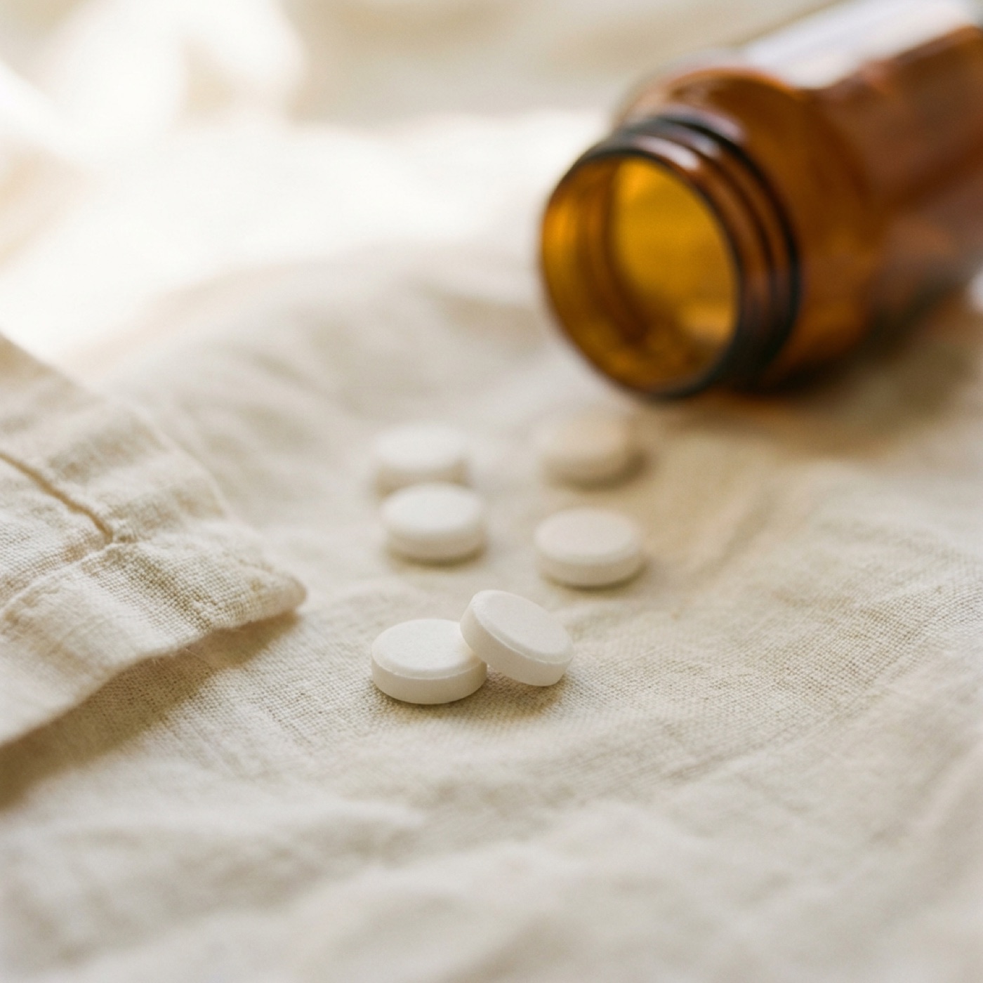 Close-up macro shot of oral dissolving GLP-1 tablets on cream linen